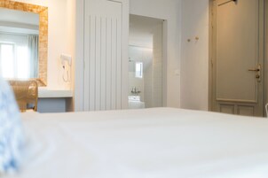 Una habitación de hotel con cama, baño con ducha y puerta.