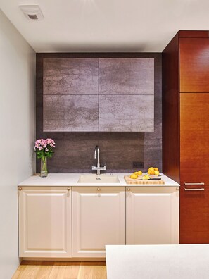A modern kitchen with a central island, a built-in sink, and a wooden cabinet. - Top-Floor Penthouse / Skyline Views / Steps from Old Town (Wrocław)