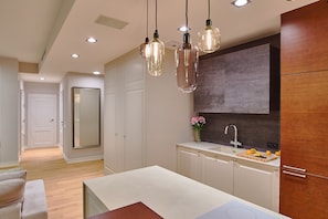 A modern kitchen with pendant lighting, a large mirror, and a built-in oven.