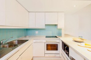 A modern kitchen with white cabinetry, a built-in oven, and a stainless steel sink. - Beautiful 3-Bedroom Home with 2 Bathrooms in London (London)