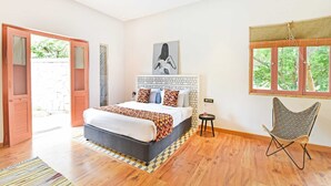 Une chambre à coucher avec un lit, une chaise, une fenêtre et une porte.