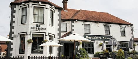 A traditional pub with outdoor seating and a sign for 'Berkshire Arms.'