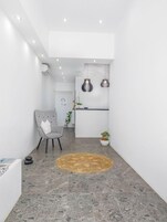 Un interior moderno con zona de cocina, una silla de comedor y un tapete redondo.