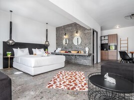 Un dormitorio moderno con cama, mesitas de noche y un baño con tocador.