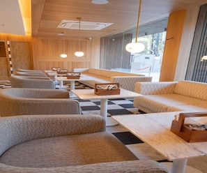 A modern interior with seating arrangements, tables, and pendant lighting.