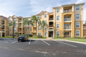 A multi-story residential building with a parking lot in front. - Vista Cay 3BR near Universal & Convention (Orlando)