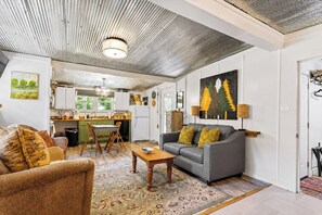 A modern living room with a grey sofa, a wooden coffee table, and a patterned rug.