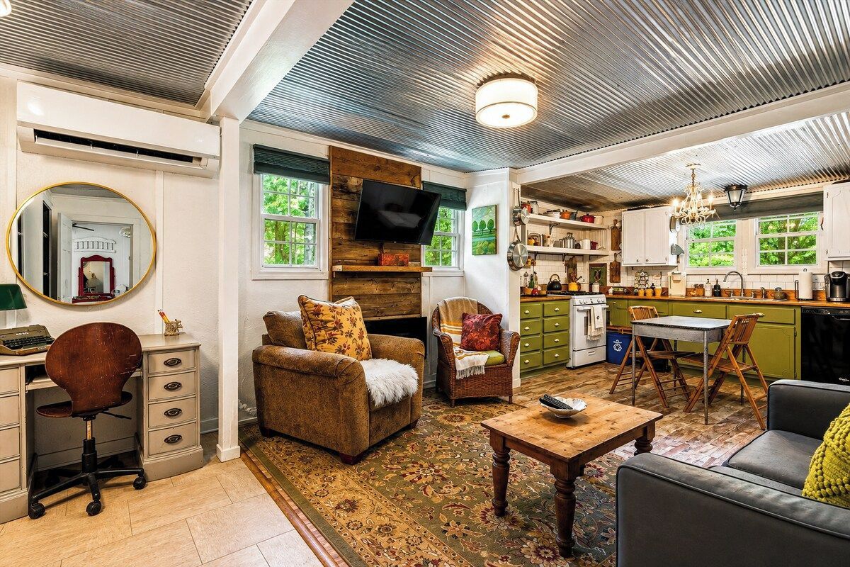 A living room with a fireplace, a television, and a dining area with a table and chairs.