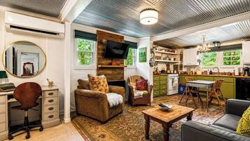 A living room with a fireplace, a television, and a dining area with a table and chairs.