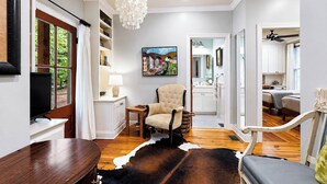 A living room with a television, a chandelier, a cowhide rug, and a painting on the wall. - The Acres, 4BR Farm Stay by Velvet Ditch Villas (Oxford)