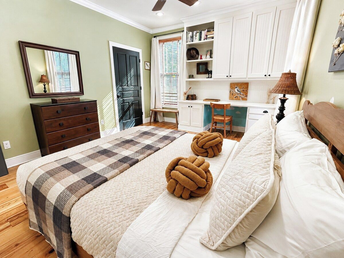 Un dormitorio con cama, cómoda, estantería y puerta.