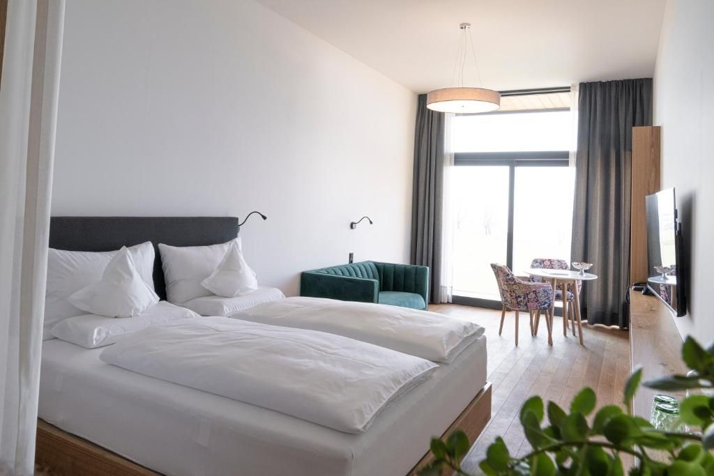 Ein Hotelzimmer mit Bett, Schreibtisch, Stuhl und Fernseher.