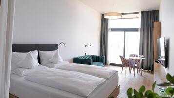 Ein Hotelzimmer mit Bett, Schreibtisch, Stuhl und Fernseher.