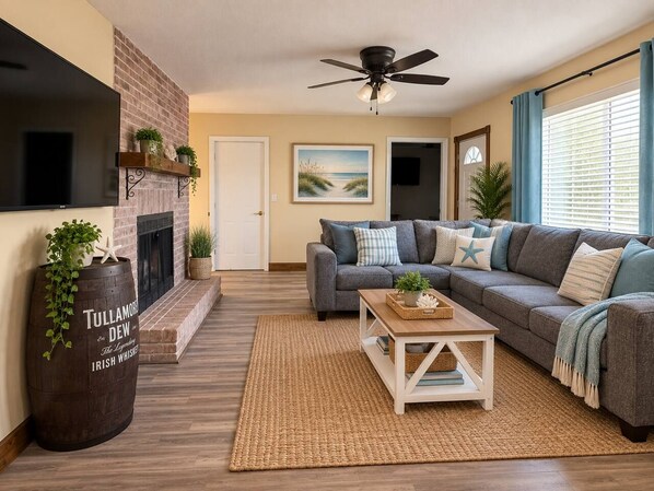 A living room with a fireplace, a sofa, a coffee table, and a TV.