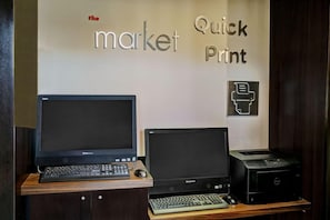 Two Lenovo desktop computers on a desk with a keyboard and mouse, a printer, and a wall sign that reads 'the market Quick Print.' - Courtyard by Marriott Kansas City Country Club Plaza (Kansas City)