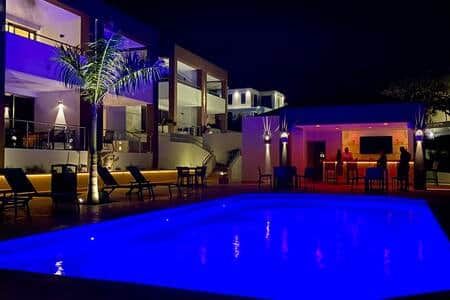Un espace piscine avec des chaises longues et un bar qui ouvre le soir.