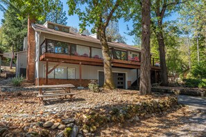 A two-story house with a balcony, a covered patio, and a stone wall. - Spacious 3-bedroom house in tranquil Lakehead unobstructed lake views (Lakehead)