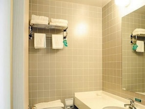 Une salle de bain avec un lavabo, un miroir et un porte-serviettes.
