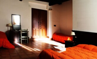 Una habitación de hotel con cama, escritorio con televisor, silla y armario.