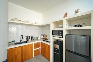 A modern kitchen with white cabinetry, a stainless steel refrigerator, a microwave, and a coffee machine. - Villa SolaFide - Stunning 2BR Pool Villa (Ungasan)