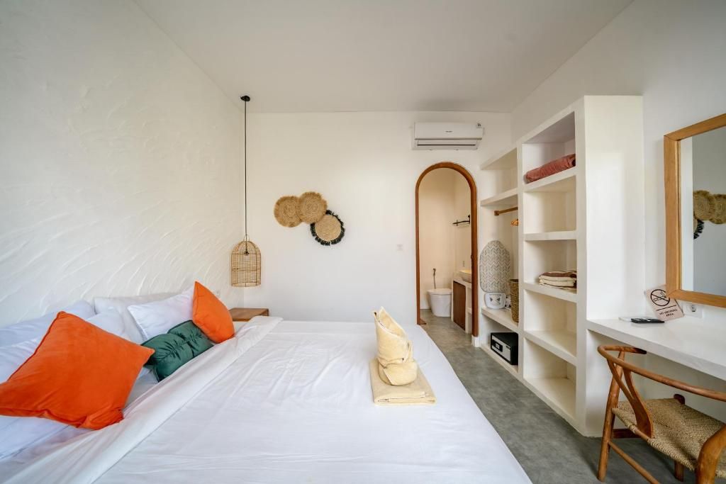 A bedroom with a bed, a desk, and a wardrobe.