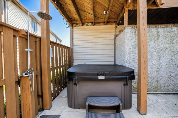 Ein Whirlpool mit Holzterrasse und überdachter Terrasse.