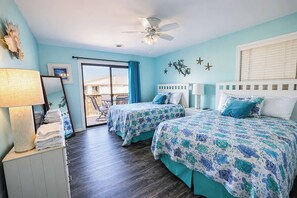 A hotel room with two beds, a ceiling fan, a balcony with a view, and a large window with blinds. - Club Ocean Villa 141 (Ocean City)