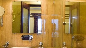Un baño con dos lavamanos, un espejo y una ducha.