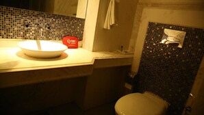 Een badkamer met een wastafel, spiegel en toilet.