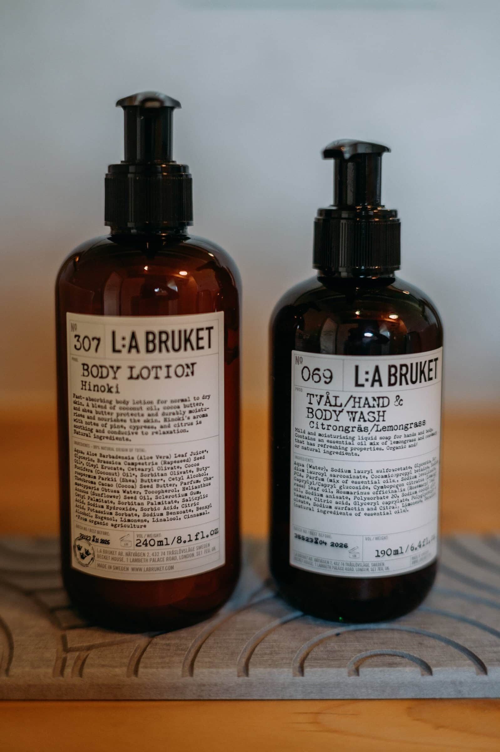 Zwei Flaschen L:A Bruket Körperlotion auf einer Holzoberfläche.