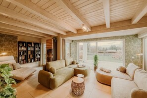 A modern living room with a sectional sofa, a coffee table, and a bookshelf.