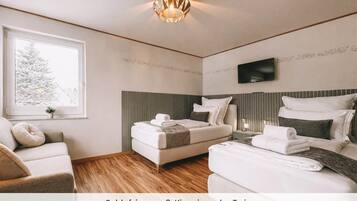 Un dormitorio con una cama tamaño king y una cama individual, ambas con toallas ordenadamente dobladas.
