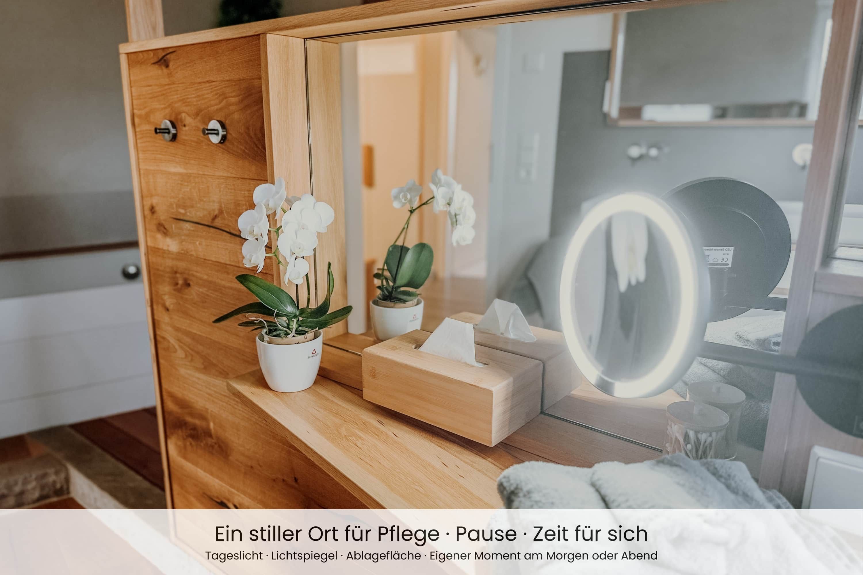 A wooden vanity with a mirror, a tissue box, and two potted plants.