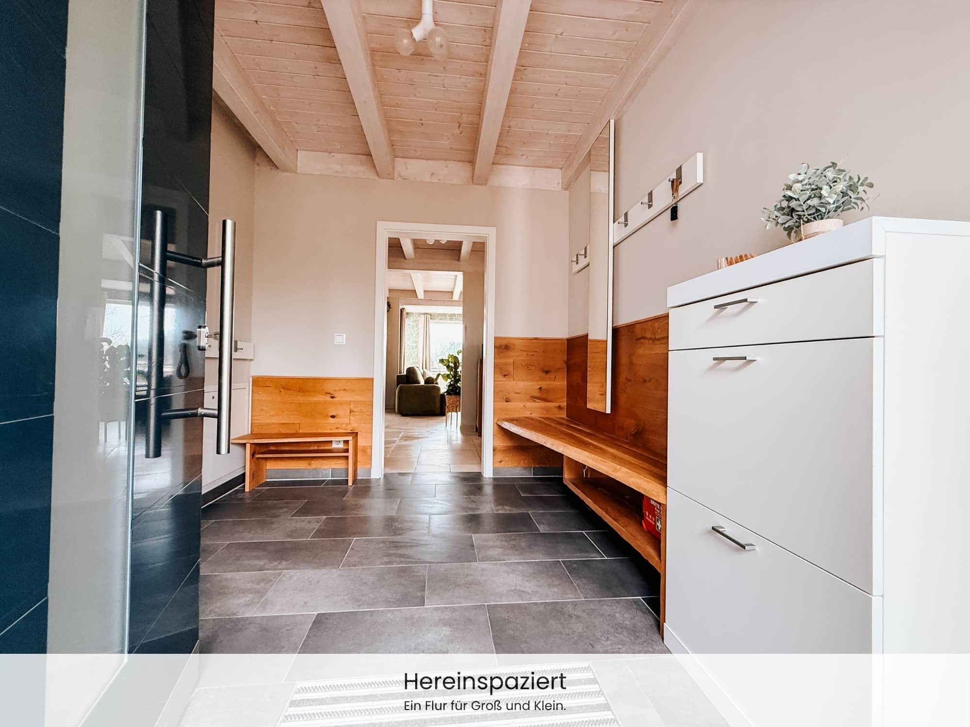Eine moderne Küche mit einer Holzbank, einem weißen Schrank und einem gefliesten Boden.