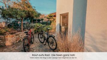 En innergård med parkerade cyklar, en stenlagd gång och en byggnad med ett fönster.