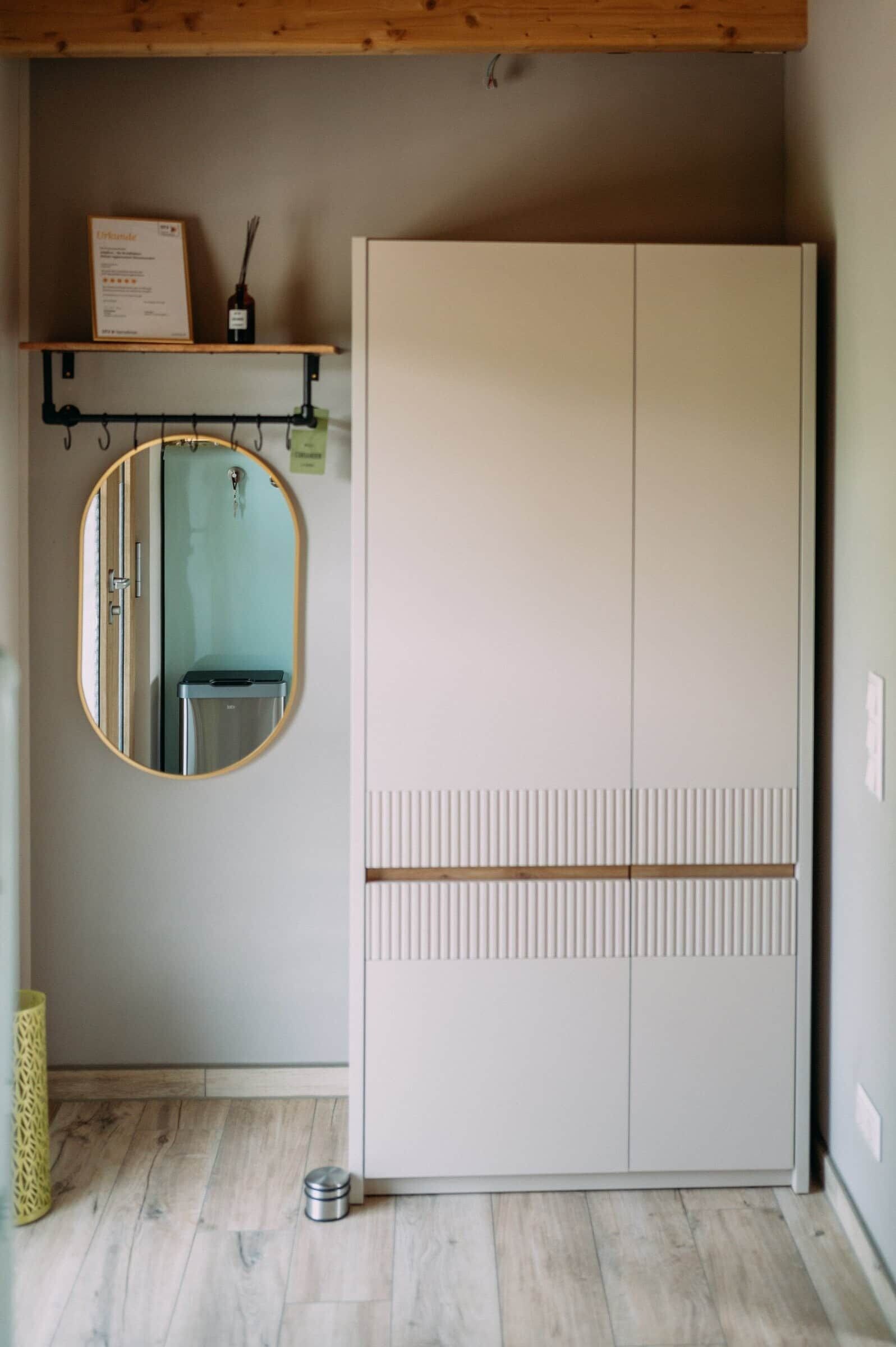 Ein Zimmer mit Schrank, Spiegel und einer Ablage mit einem Zertifikat.