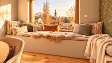 A cozy seating area with a view of a building and trees.