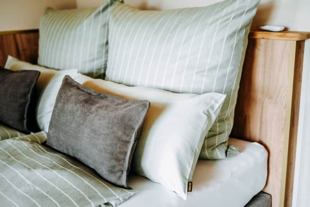 A bed with striped bedding and multiple pillows.
