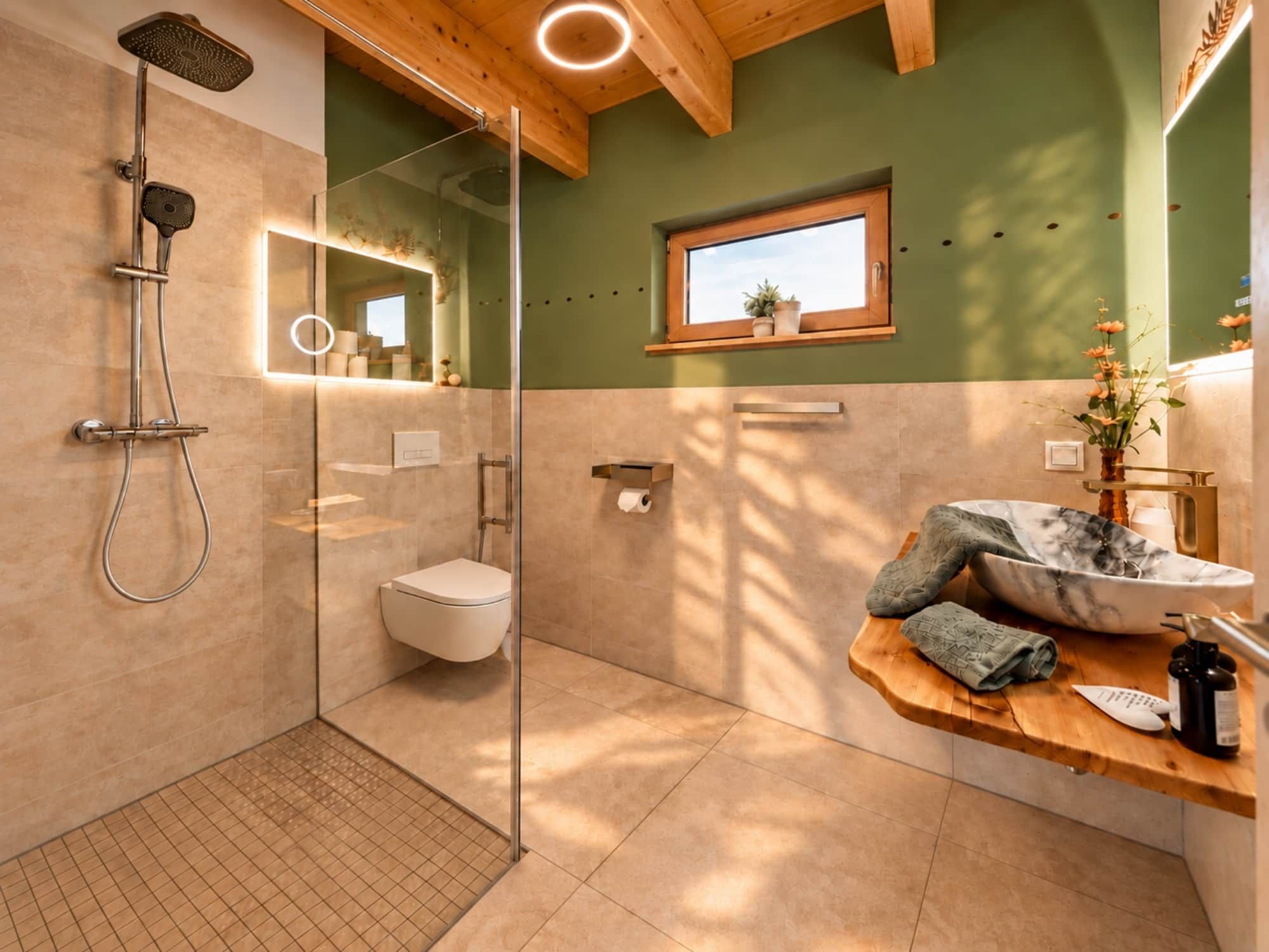 Ein modernes Badezimmer mit Duschkabine aus Glas, Toilette und Waschtisch mit Marmorbecken.
