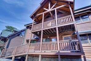 Un immeuble en bois à plusieurs étages, doté d’un balcon et d’une fondation en pierre.