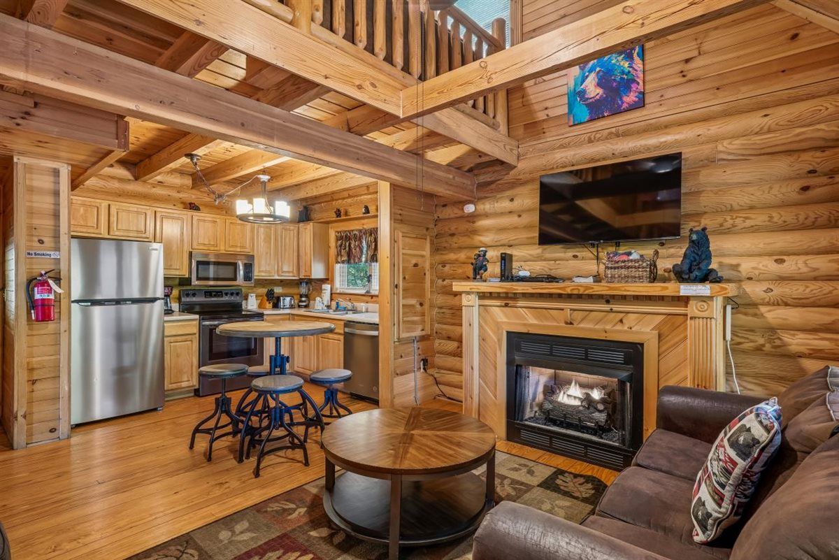 L’intérieur d’une cabane en rondins comprend une cuisine, un coin repas et un salon.