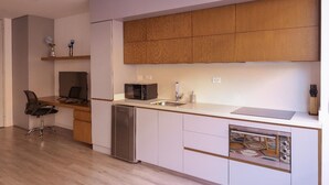 A modern kitchen with wooden cabinets, a microwave, a sink, and a dishwasher. - Studio in Unicentro|Santa Barbara|Clinica Santafe (Bogotá)