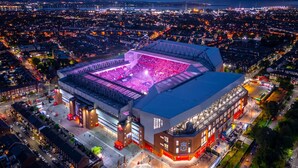 Ein Stadion mit großer Zuschauertribüne und überdachtem Bereich, umgeben von Stadtgebäuden und Straßen.
