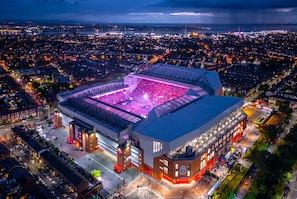 A stadium with a large seating area and a covered section, surrounded by urban buildings and roads. - En-Suite Rooms · Sleeps 8 · 5 Min Walk to Anfield Stadium (Anfield)