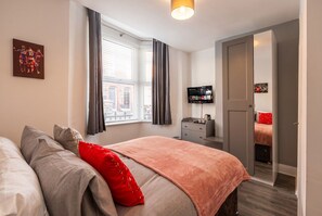 A hotel room with a bed, a television, a wardrobe, and a window with curtains. - En-Suite Rooms · Sleeps 8 · 5 Min Walk to Anfield Stadium (Anfield)