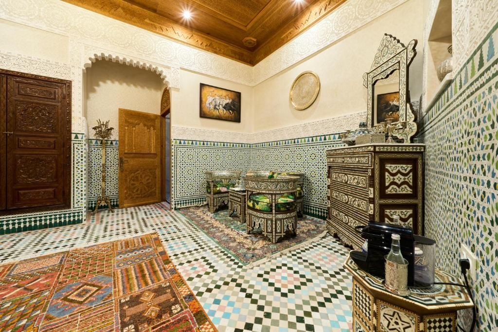 A room with a checkered floor, ornate wooden furniture, and a decorative mirror.