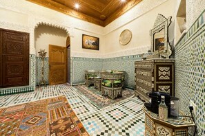 A room with a checkered floor, ornate wooden furniture, and a decorative mirror. - Riad May Fes Original & Spa (Fès)