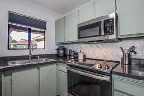 A modern kitchen with a built-in microwave, stove, and sink.
