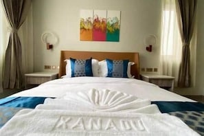 A hotel room with a large bed, a headboard with decorative elements, a painting on the wall, and curtains on the windows. - B8-Xanadu Blue Bay Sleeps 4 (Sint Michiel)