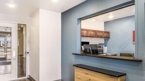 A modern kitchen with a large mirror, wooden cabinets, and a countertop. - Value Place Beaumont, TX (Beaumont)